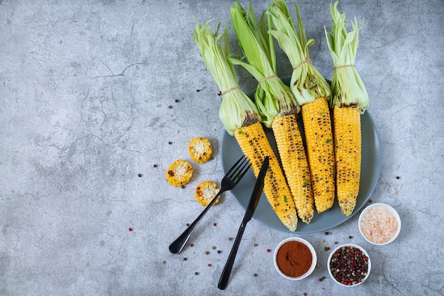 Grilled sweet corn cobs with herbs, salt, and spices