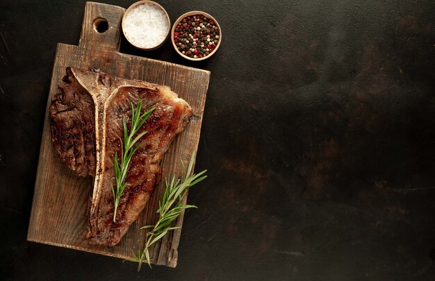 Grilled T-bone steak on a stone table. With copy space for your text.
