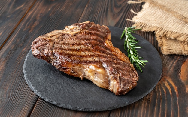 Grilled T-bone steak with fresh rosemary on the stone board