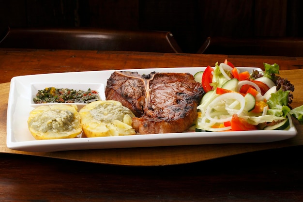 Grilled T bone steak with salad and potatoes