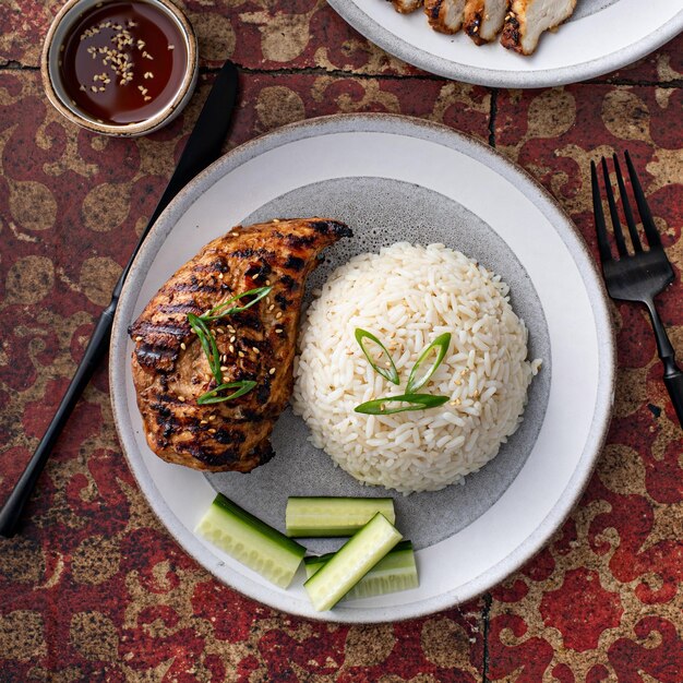 Grilled teriyaki chicken breast with rice and fresh cucumber