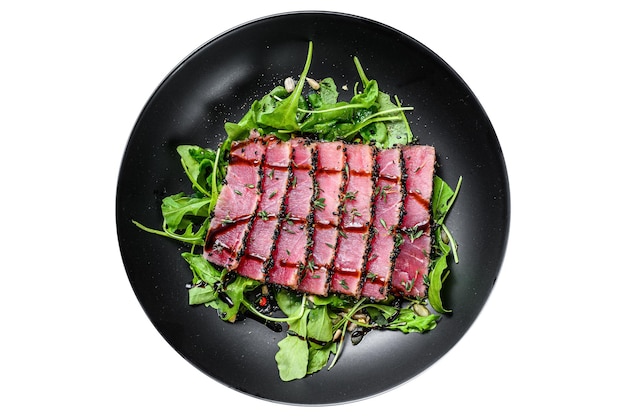 Grilled teriyaki Tuna steak salad with arugula and spinach Isolated on white background