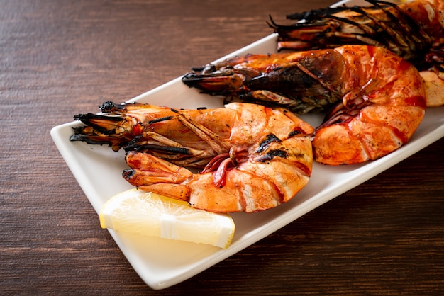 grilled tiger prawns or shrimps with lemon on plate