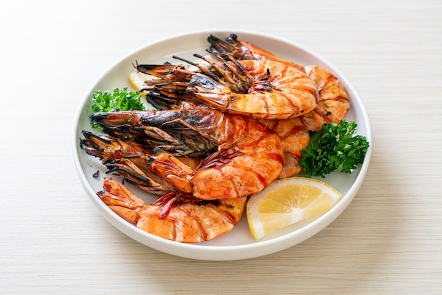 grilled tiger prawns or shrimps with lemon on plate