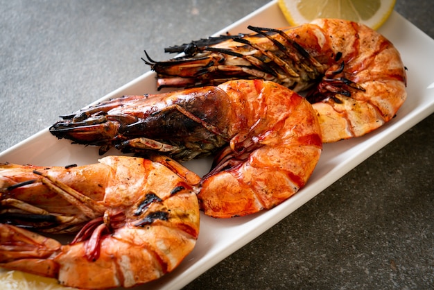 grilled tiger prawns or shrimps with lemon on plate