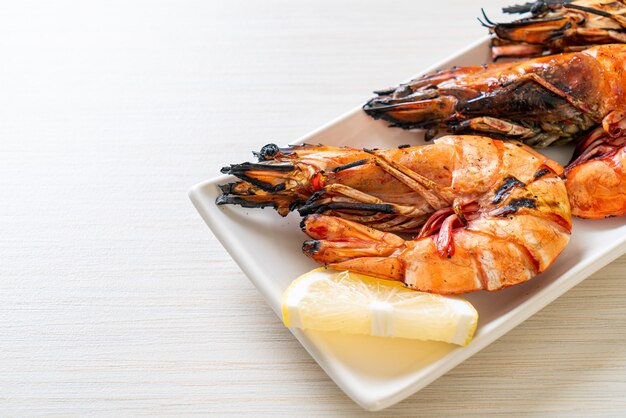 grilled tiger prawns or shrimps with lemon on plate