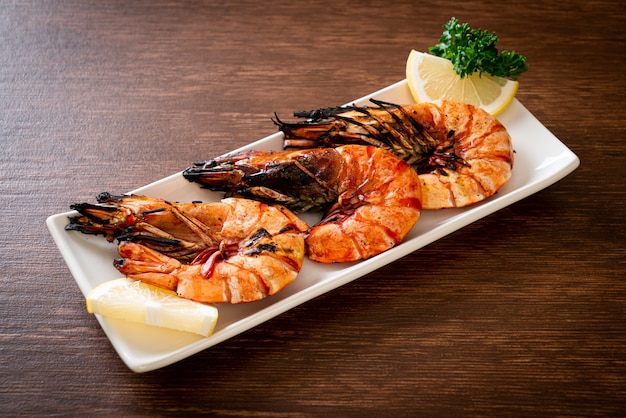 grilled tiger prawns or shrimps with lemon on plate