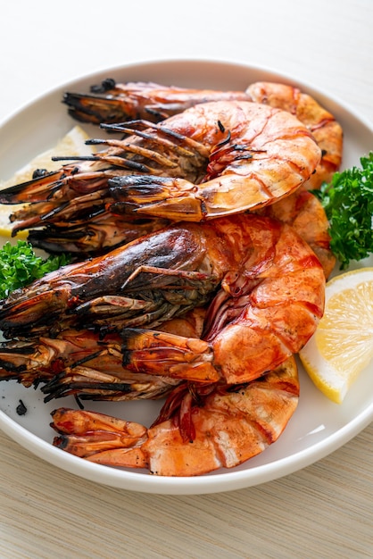grilled tiger prawns or shrimps with lemon on plate