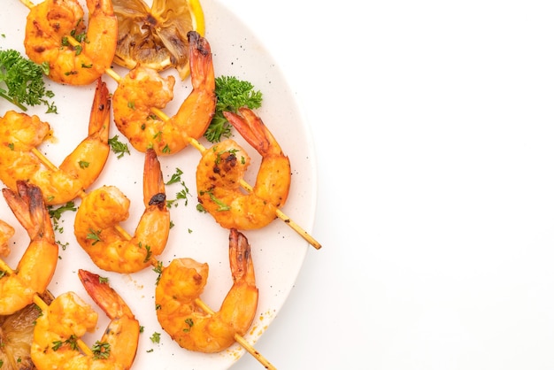 Grilled tiger shrimps skewers with lemon