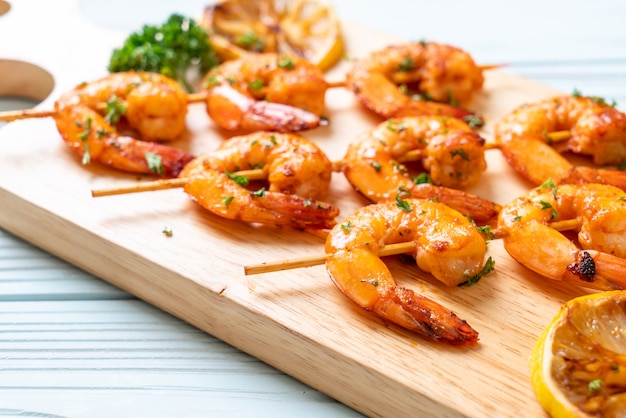 Grilled tiger shrimps skewers with lemon