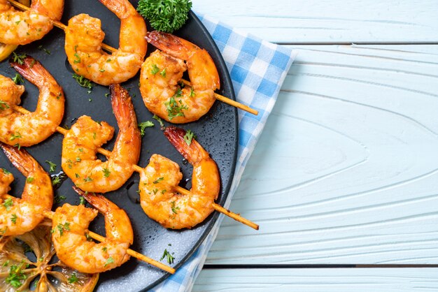 Grilled tiger shrimps skewers with lemon