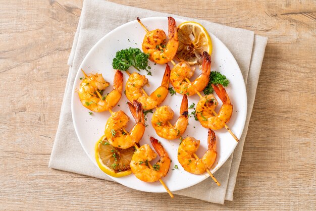 Grilled tiger shrimps skewers with lemon