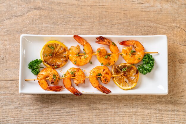 Grilled tiger shrimps skewers with lemon