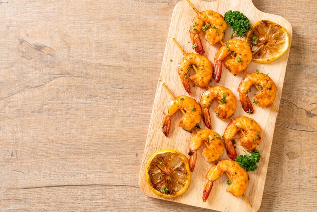 Grilled tiger shrimps skewers with lemon