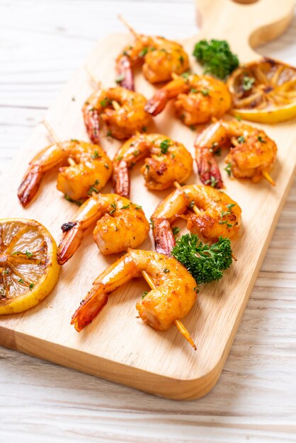 Grilled tiger shrimps skewers with lemon