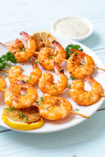 Grilled tiger shrimps skewers with lemon