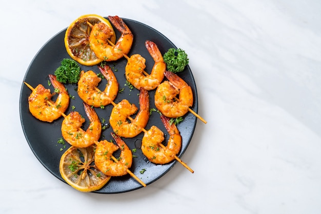 Photo grilled tiger shrimps skewers with lemon