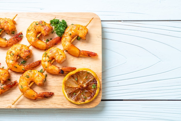 Grilled tiger shrimps skewers with lemon