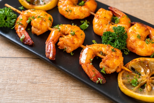 Grilled tiger shrimps skewers with lemon