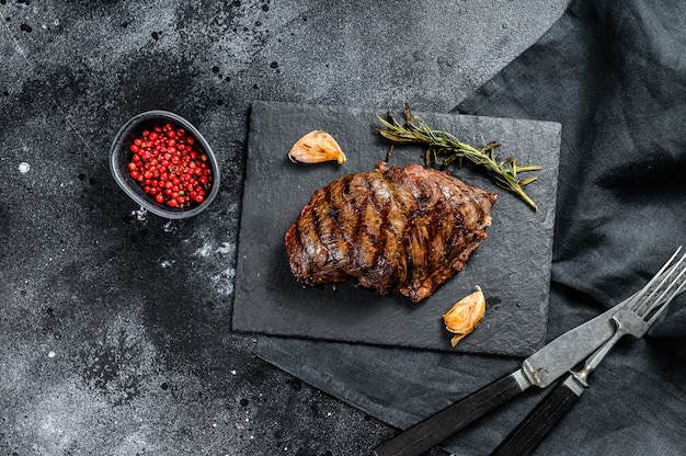 Grilled Top Blade steak on a stone Board, marbled beef. Top view