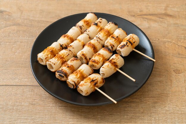 Grilled tube shaped fish paste cake skewe or tube squid\
skewer