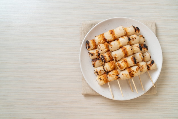 grilled tube shaped fish paste cake or tube squid skewer on plate