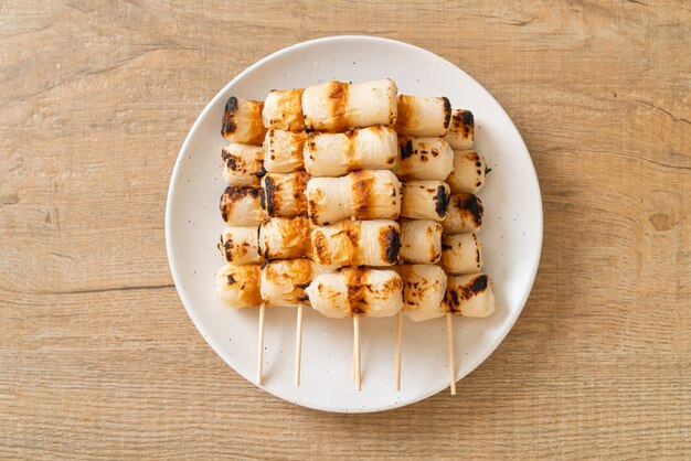 grilled tube shaped fish paste cake or tube squid skewer on plate