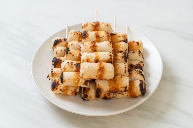 焼き魚のペーストケーキまたはプレート上のチューブイカの串焼き