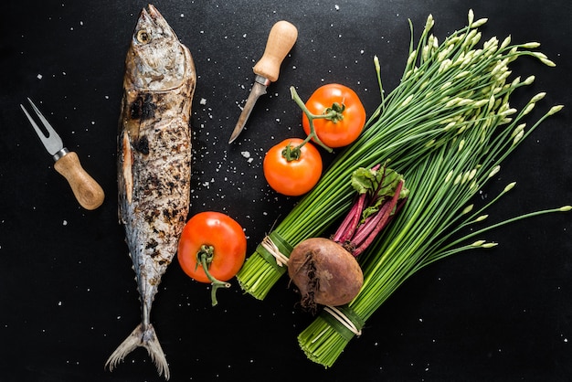 暗い背景に野菜とマグロのグリル魚