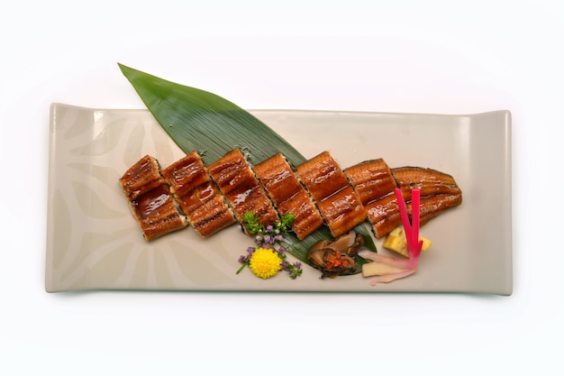 Grilled unagi eel with soy based sauce on plate in Japanese styl