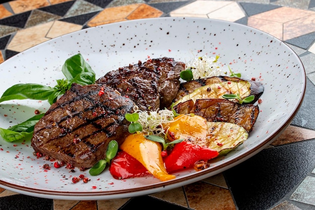 Grilled veal steak with vegetables and basil