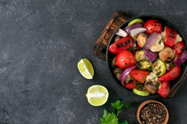 Verdure grigliate su sfondo nero. menu vegano. mix di verdure in un piatto