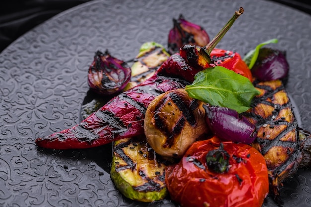 Grilled vegetables on a black plate