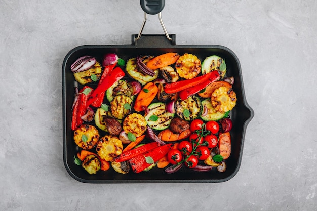 Grilled vegetables in a cast iron pan top view copy space