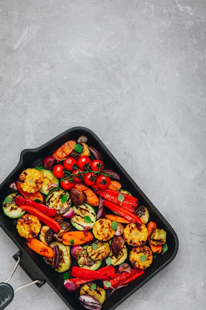 Photo grilled vegetables in a cast iron pan top view copy space