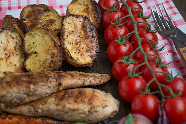 Grilled vegetables on a cutting board on a dark wooden background. Dark wooden background.