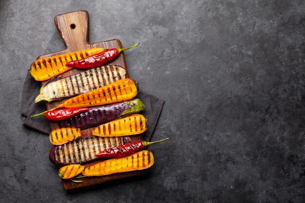 Grilled vegetables on cutting board with spices and herbs top view flat lay with copy space