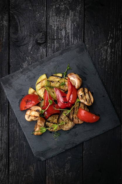 Grilled vegetables peppers eggplant champignons on a slate plate