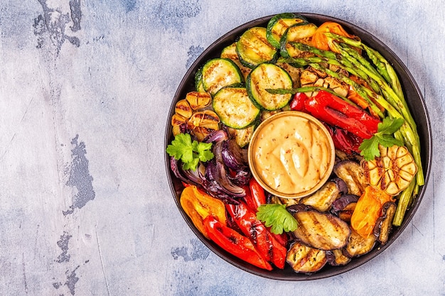 Grilled vegetables on a plate with sauce