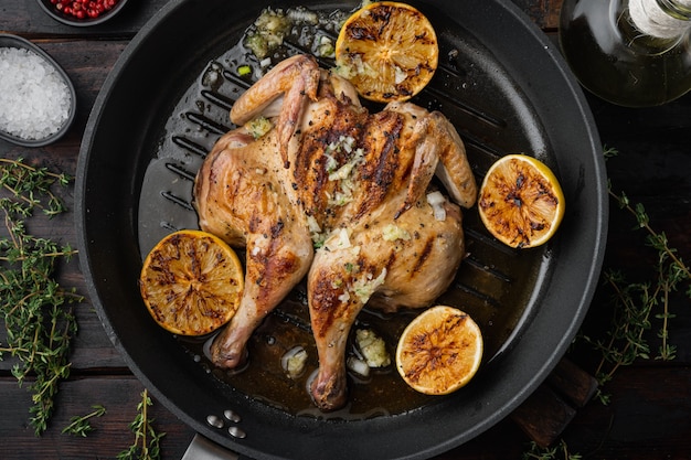 Grilled whole chicken, on old wooden table, top view