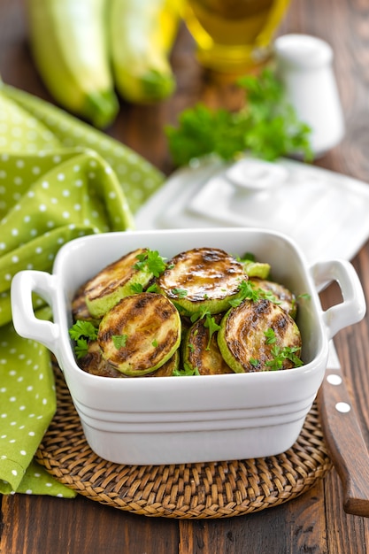 Grilled zucchinis in bowl closeup