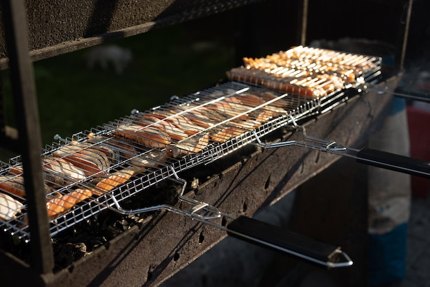 Grigliare il pesce alla griglia durante un picnic