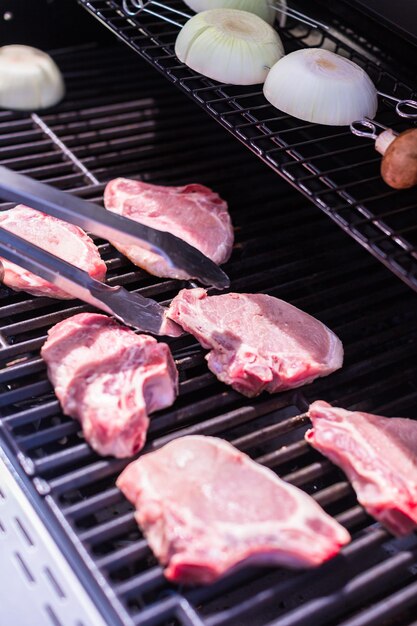 Grilling pork chops on gas grill in the Summer.