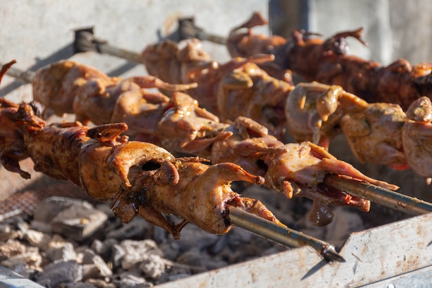 Grilling quails over charcoal stove