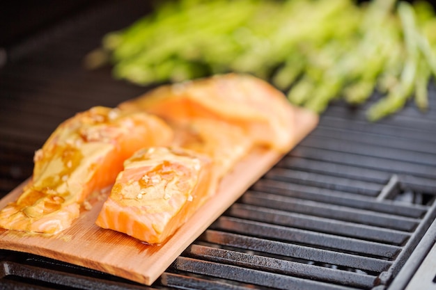 Grilling salmon on cedar plank on outdoor gas grill.