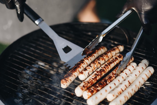 Grilling sausages on barbecue grill Selective focus