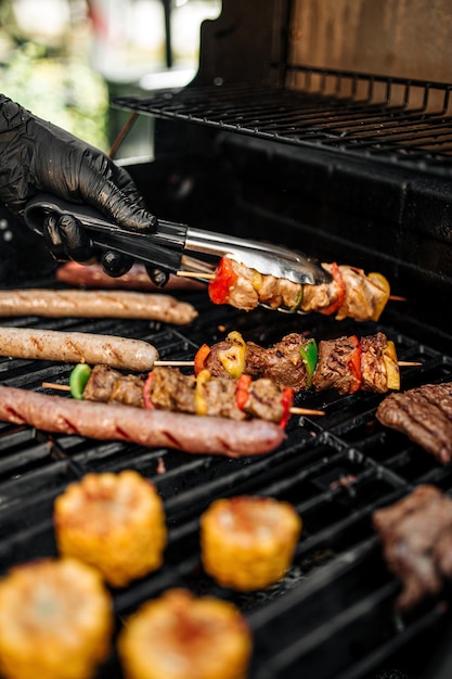 Grilling sausages skewers and corn on a barbecue