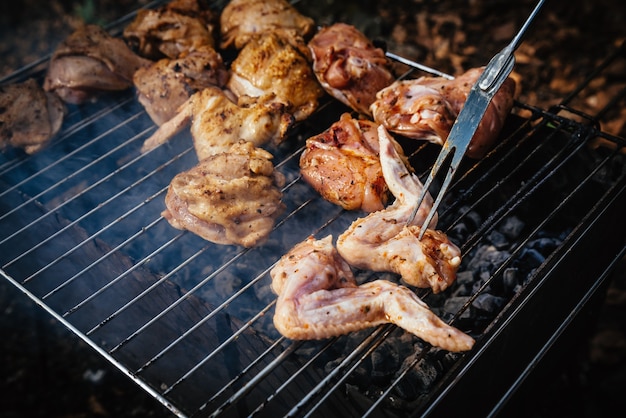 Grilling spiced chicken in grid on charcoal bbq. Shalow DOF.