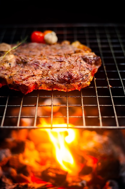 Grilling T Bone Steak on flaming grill