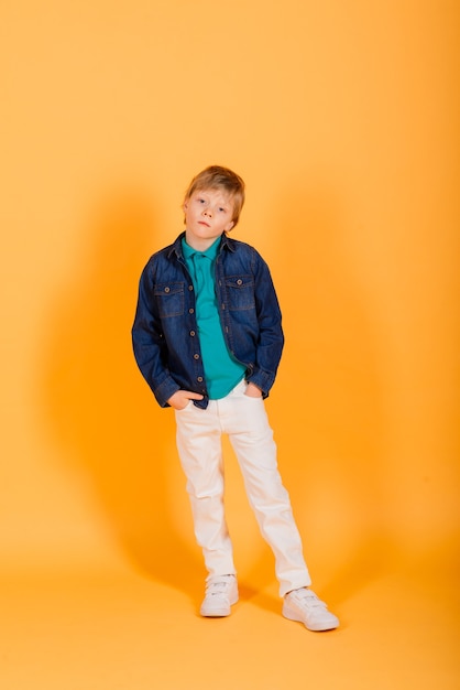 Grimacing emotional redhead fasion boy posing in a yellow studio